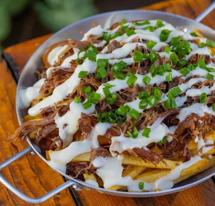Frigideira com batata frita, costela desfiada, creme e cebolinha, prato de um parceiro