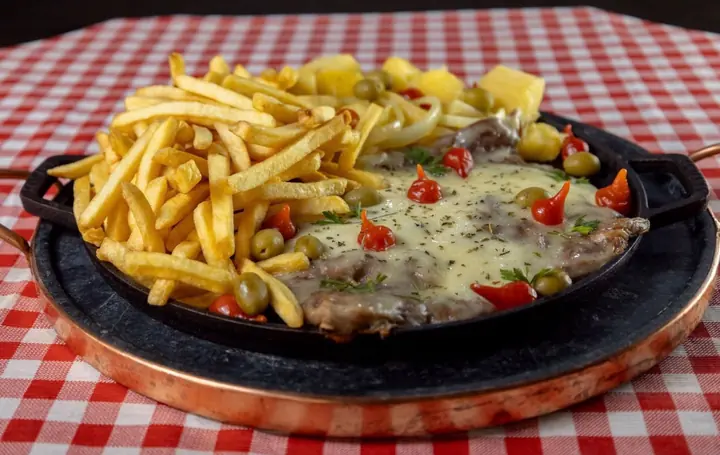 Frigideira de costela com queijo e batata frita, prato de um parceiro