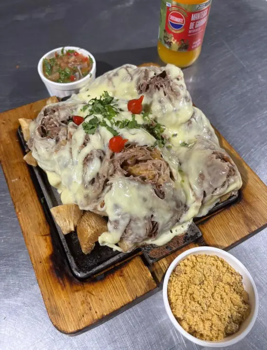 Costela com queijo numa tábua, com farofa, prato de um parceiro