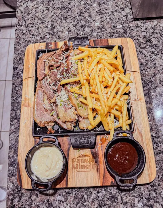 Tábua com costela, batata frita e molhos, prato de um parceiro
